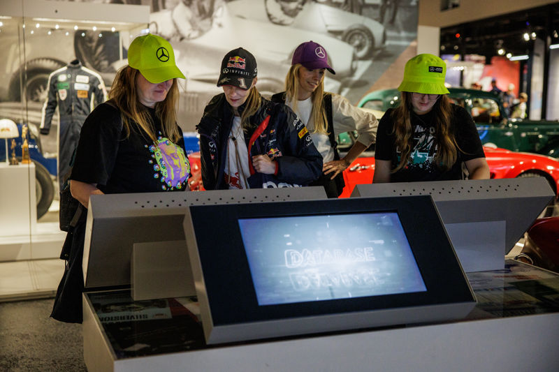A group of young women interact with the touch screens at Silverstone Museum in the Tech Lab