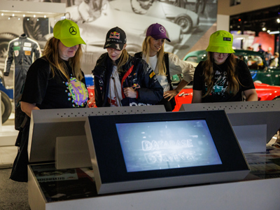A group of young women interact with the touch screens at Silverstone Museum in the Tech Lab
