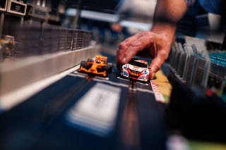 A Honda Civic touring car and McLaren Formula 1 car line up on the Scalextric grid of Silverstone Circuit
